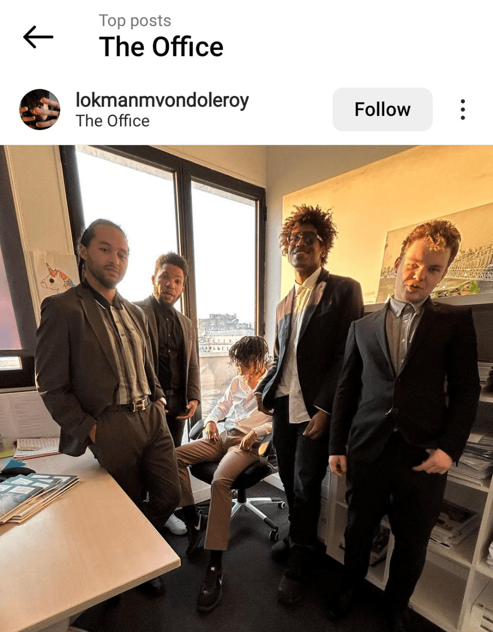 Instagram image of a group of people dressed in suits in an office with the geotag 'The Office'. 