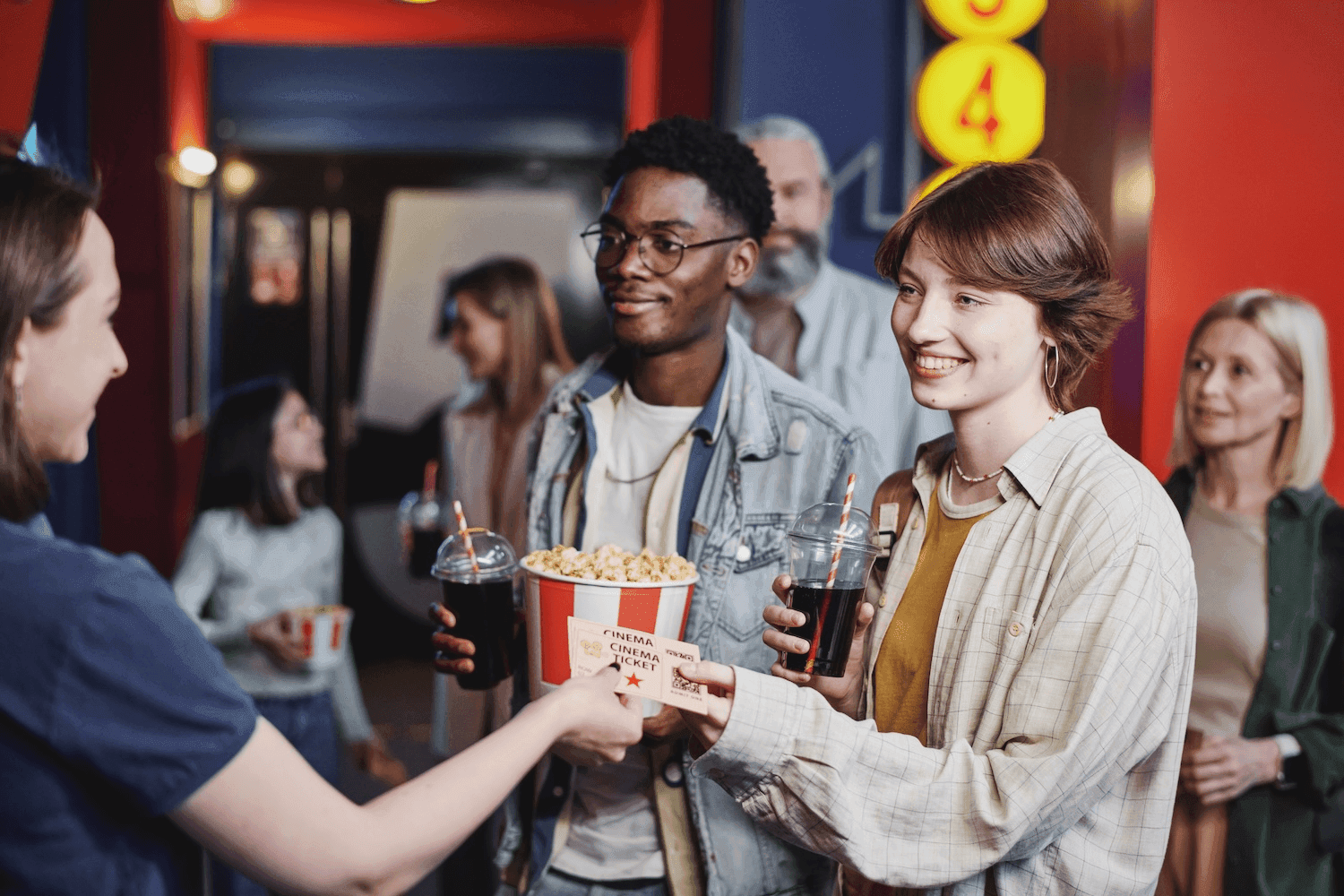 A group of people holding popcorn and drinks going to the movies in New York City