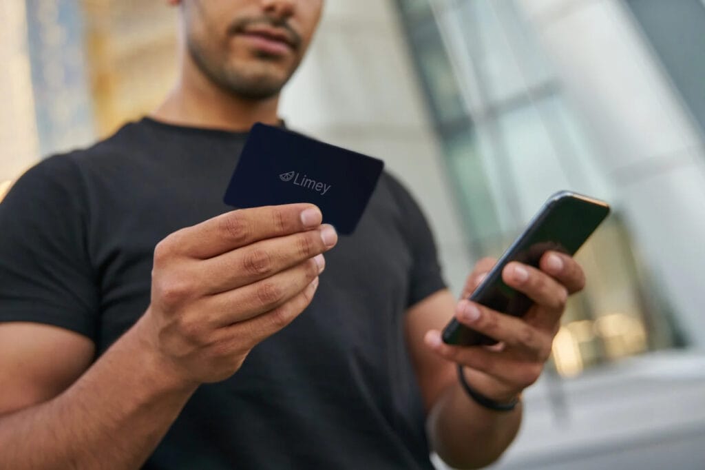 A man holding an NFC Business Card and a smart phone